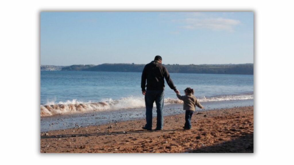 parent with child on beach 